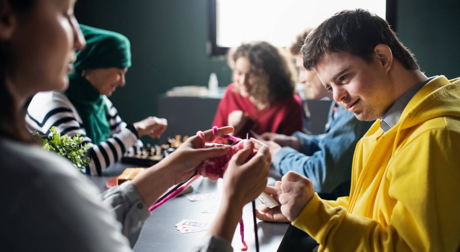 Group of people playing cards and board games in community center